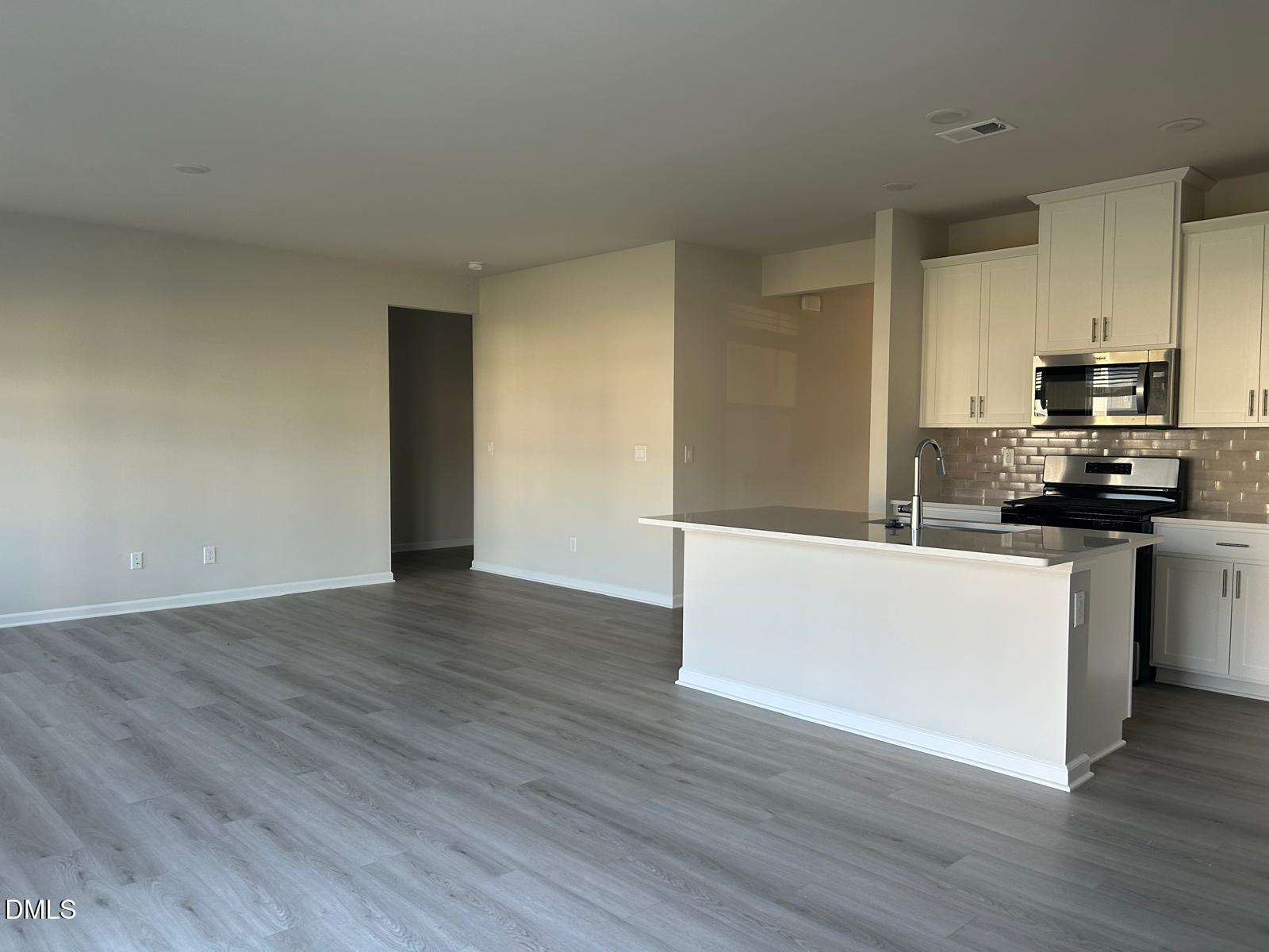 1220 Whitespire Way Zebulon, NC 27597 - Photo 5 of 20 a kitchen with wooden floors and white appliances