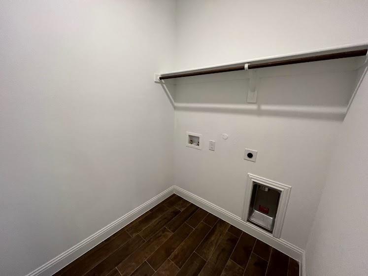 1408 Rendyn Street Anna, TX 75409 - Photo 14 of 23 Utility room featuring wood-finish flooring, white painted walls, a pet door opening, electrical outlets, and a retractable drying rack mounted above