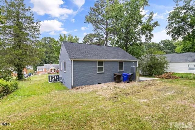 a view of a house with a patio and a yard