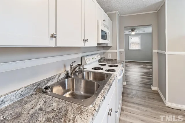 a kitchen with sink a stove and cabinets