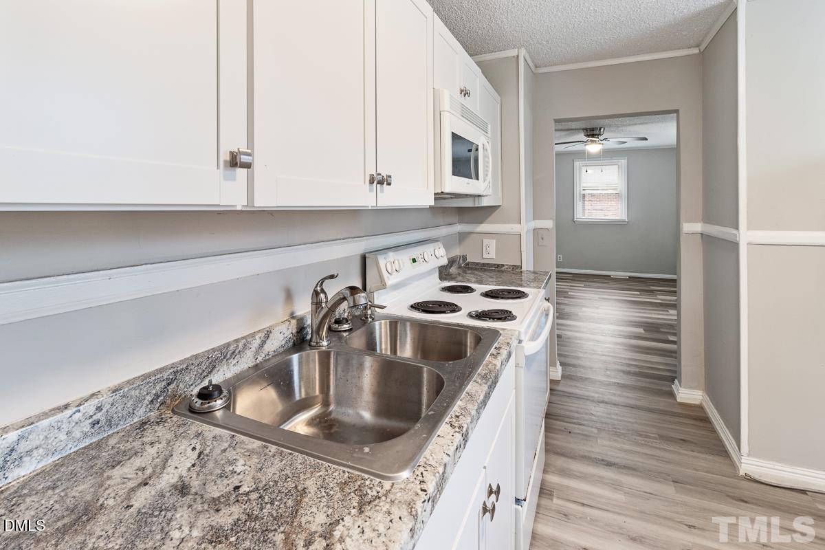 2509 White Oak Avenue Durham, NC 27707 - Photo 8 of 15 a kitchen with sink a stove and cabinets