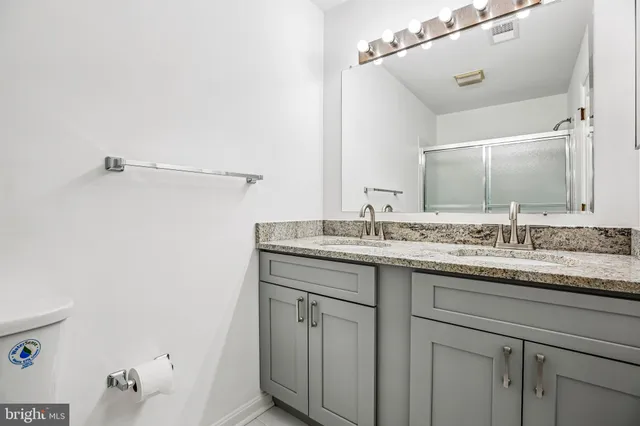 a bathroom with a granite countertop sink and a mirror