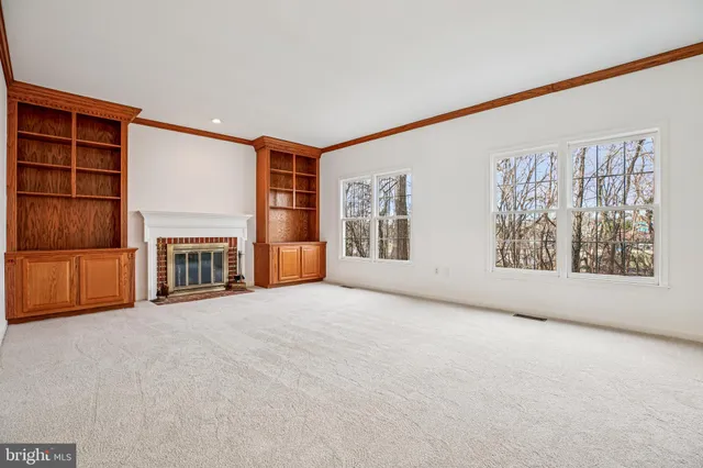 a view of an empty room with a fireplace and a window