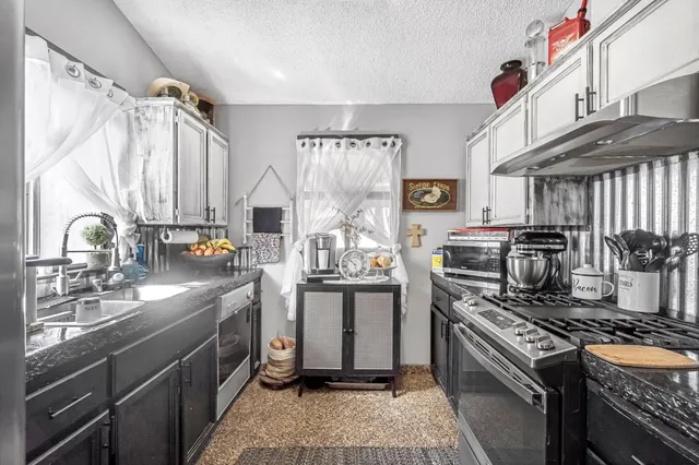 a kitchen with stainless steel appliances granite countertop a stove and a sink