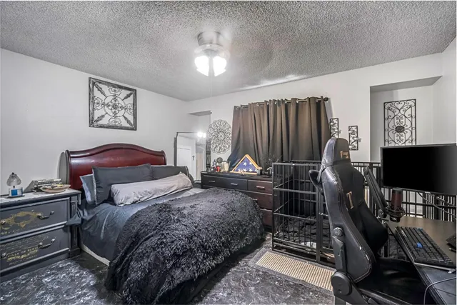 a bedroom with a bed and a flat tv screen on dresser