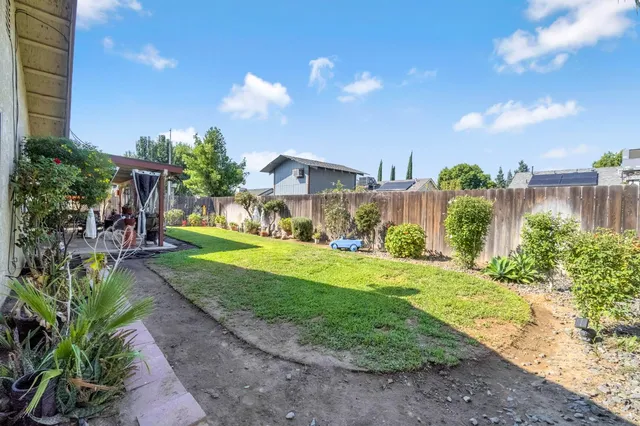 a view of a house with a yard and potted plants