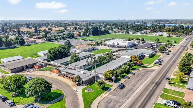 an aerial view of a city with lots of residential buildings ocean and mountain view in back