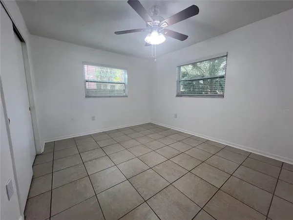 a view of an empty room and chandelier fan