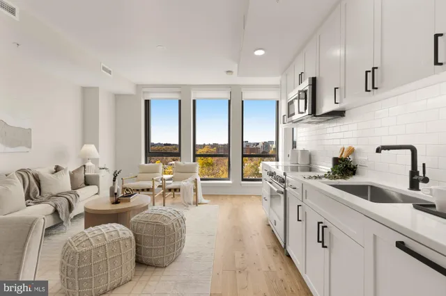 a living room with furniture and large windows
