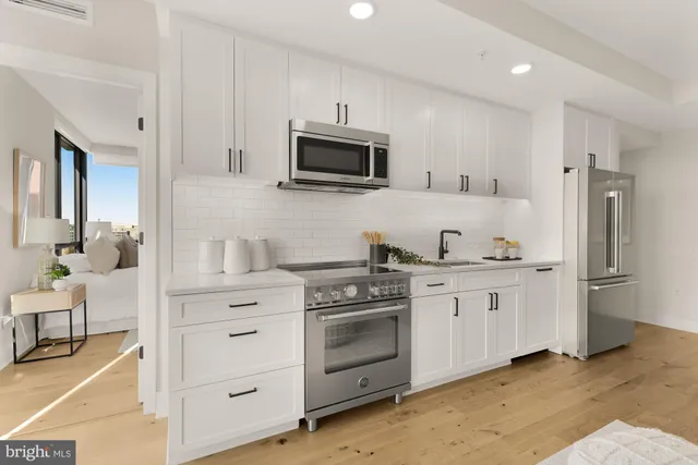 a kitchen with stainless steel appliances granite countertop a stove a sink and a refrigerator