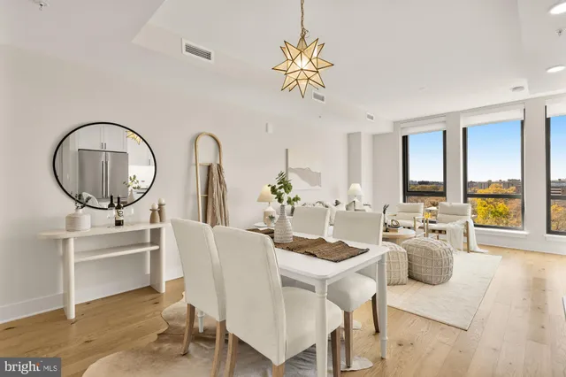 a dining room with furniture a chandelier and wooden floor