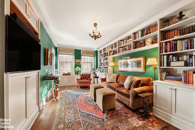 a living room with furniture a flat screen tv and a rug