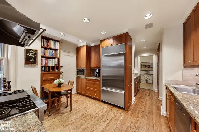 a kitchen with stainless steel appliances granite countertop a refrigerator and wooden floor