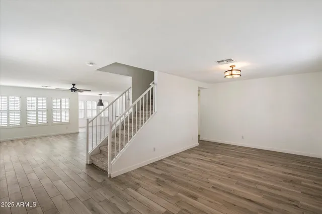 a kitchen with kitchen island stainless steel appliances a stove refrigerator and a wooden floor