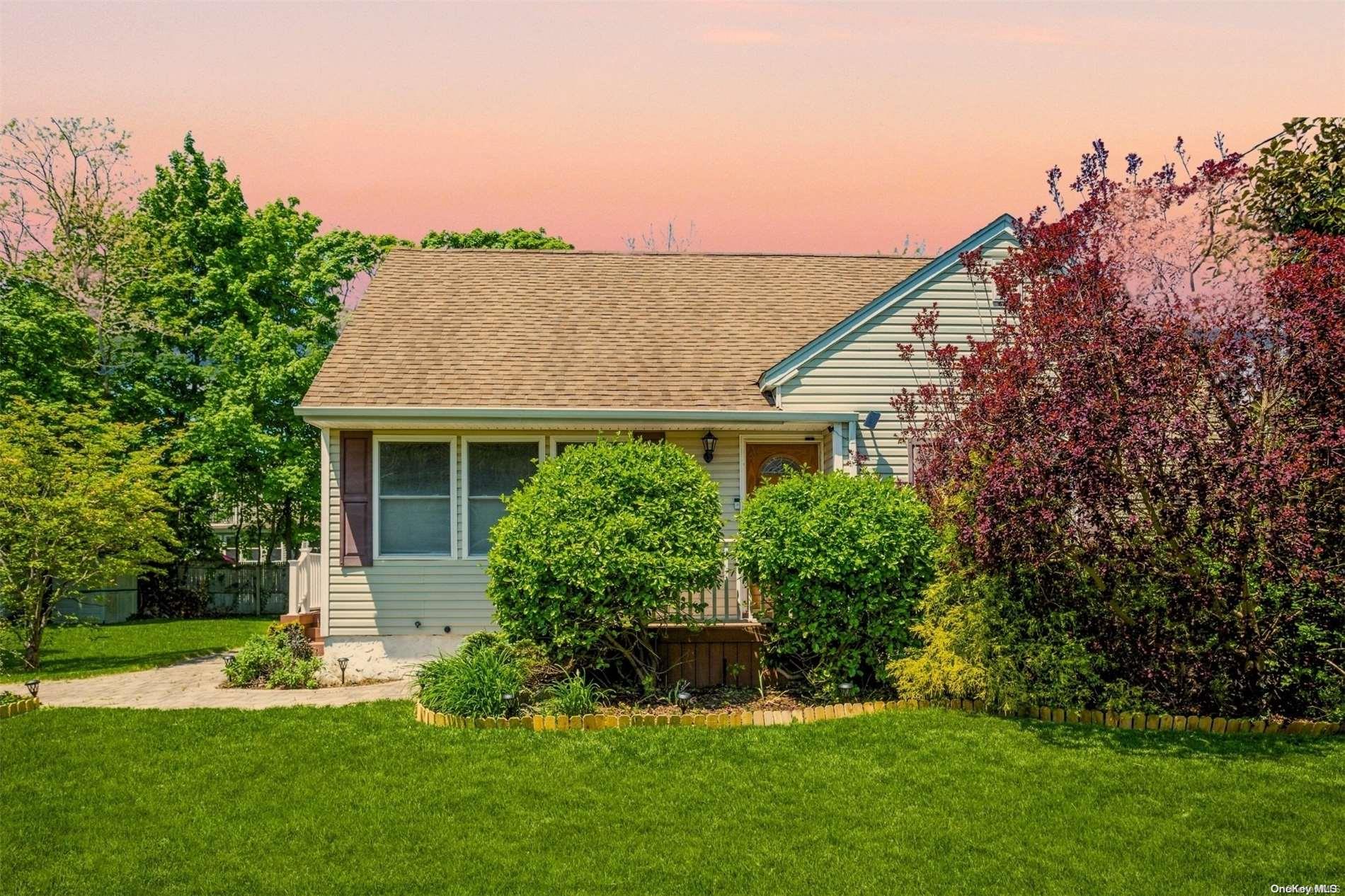 a front view of a house with a garden and plants