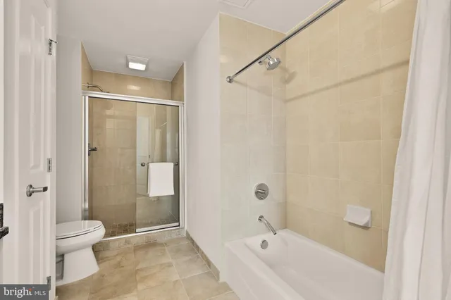 a bathroom with a granite countertop sink a toilet a mirror and shower