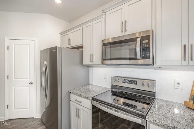 a kitchen with granite countertop a sink and cabinets