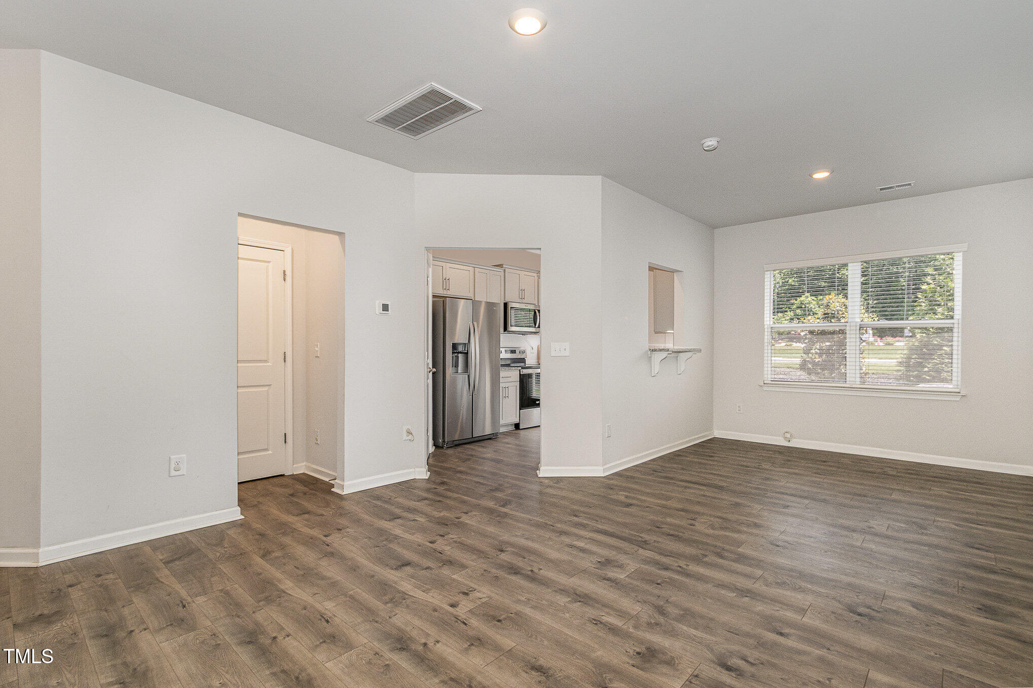 1230 Adrian Court Mebane, NC 27302 - Photo 4 of 31 a view of an empty room with wooden floor and a window