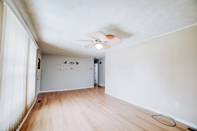 a kitchen with stainless steel appliances granite countertop a refrigerator a sink dishwasher a stove and white countertops with wooden floor