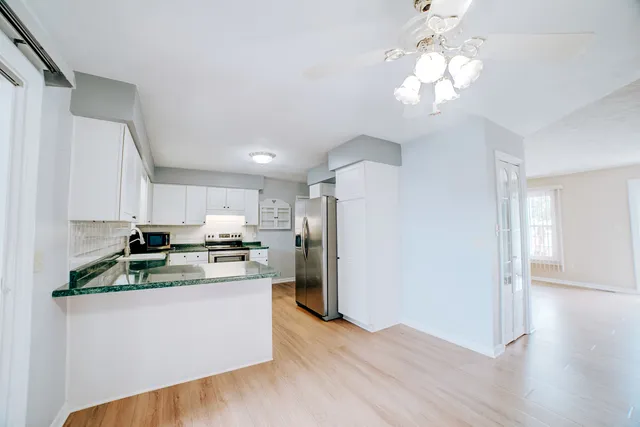 a kitchen with stainless steel appliances granite countertop a refrigerator and a stove top oven