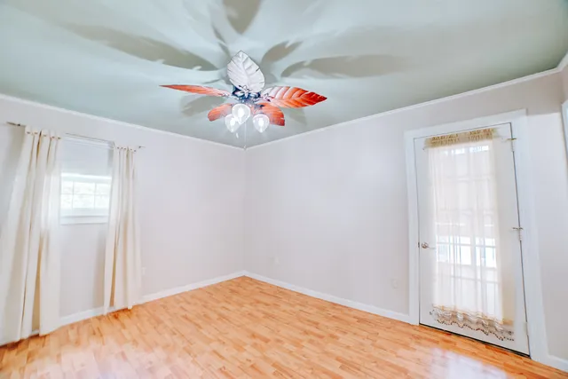 a view of an empty room with window and a ceiling fan