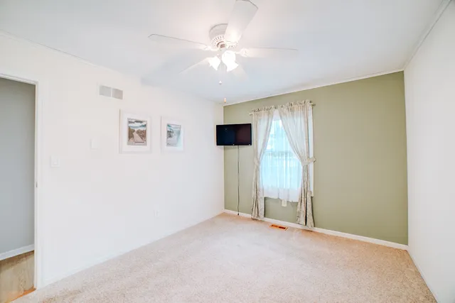 a view of an empty room with cabinet and stairs