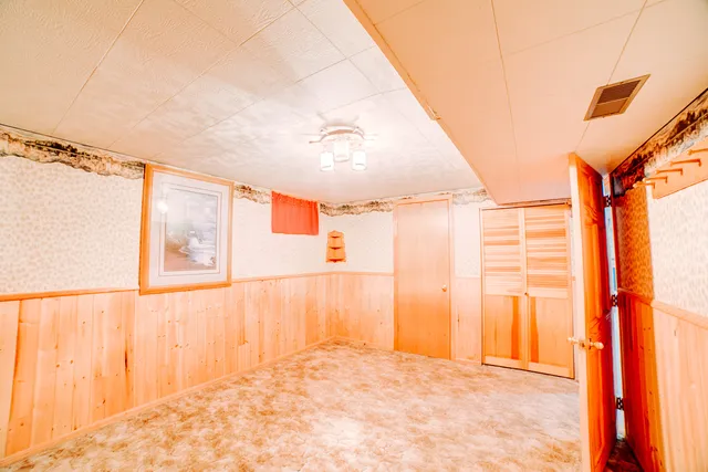 an empty room with wooden floor and door