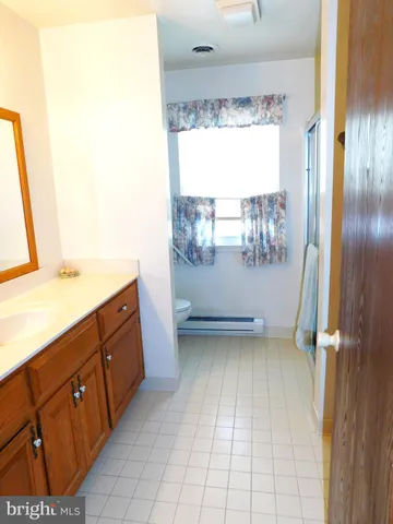 a bathroom with a granite countertop shower and a toilet