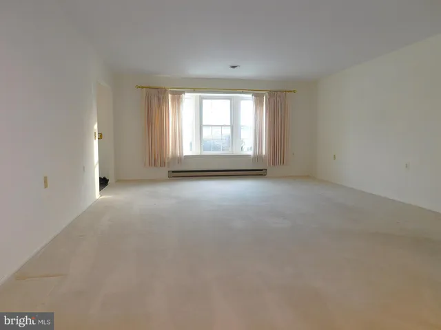 a view of a big room with windows and chandelier fan