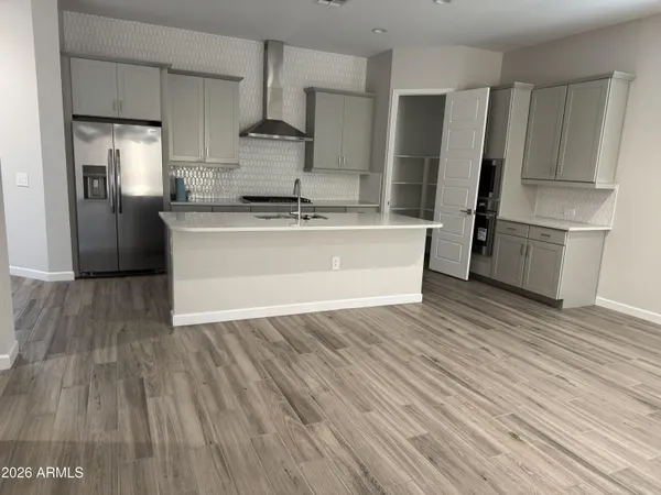 a kitchen with wooden floors and refrigerator
