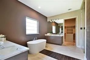 a bathroom with a tub sink and mirror