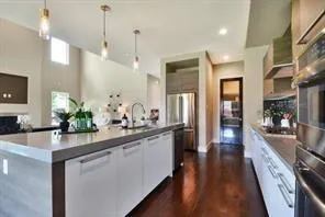 a kitchen with stainless steel appliances kitchen island granite countertop a stove a sink and a refrigerator