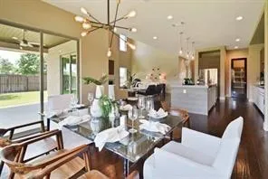 a view of a dining room with furniture a chandelier and wooden floor