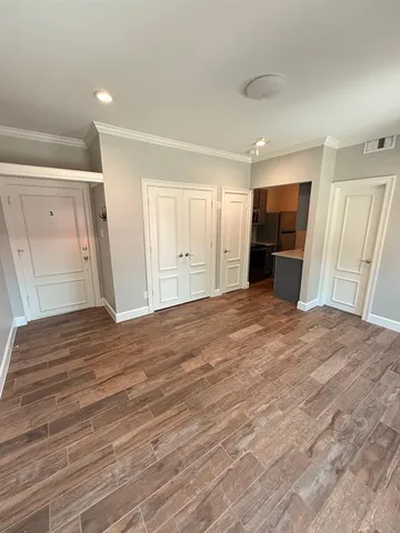 a view of empty room with wooden floor