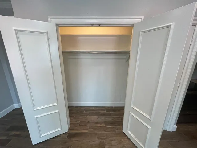 a view of walk in closet with a hardwood