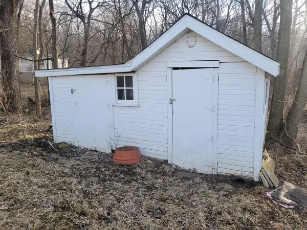 a view of a small white house with a small yard