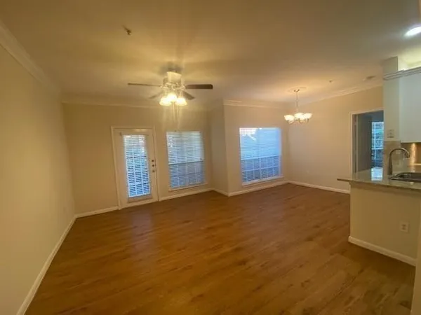a view of an empty room with window and wooden floor