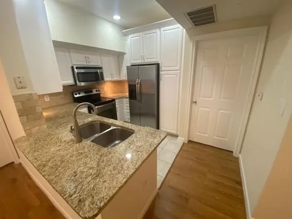 a kitchen with stainless steel appliances granite countertop a sink stove and refrigerator