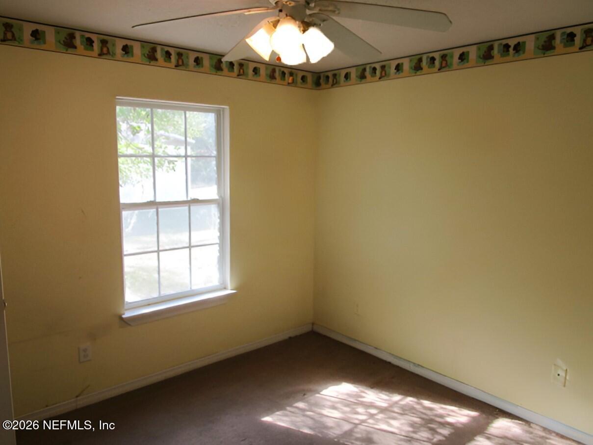 7070 3rd Street St. Augustine, FL 32092 - Photo 15 of 22 a view of an empty room with chandelier fan and windows