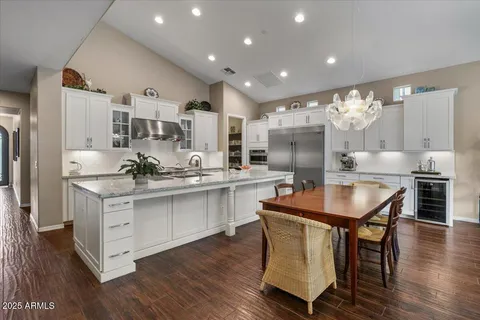 a kitchen with stainless steel appliances granite countertop a kitchen island a stove a table and chairs in it