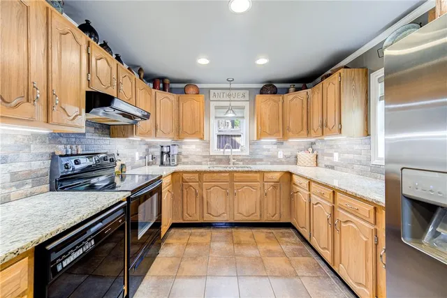 a kitchen with stainless steel appliances granite countertop a sink and a stove