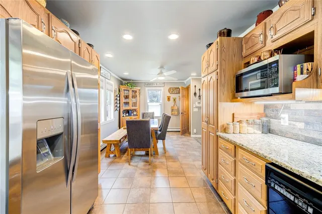 a open kitchen with stainless steel appliances granite countertop a sink and a refrigerator