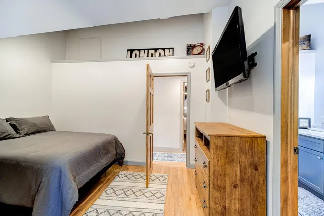 a bedroom with a bed and a flat tv screen on the wall