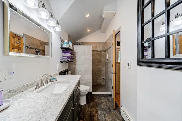 a bathroom with a granite countertop sink a mirror and shower