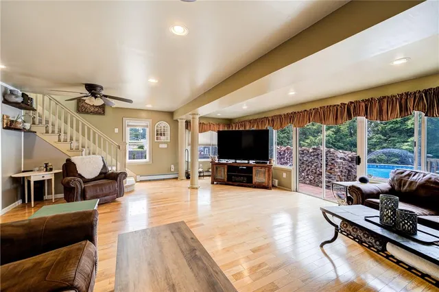a living room with furniture flat screen tv and a large window