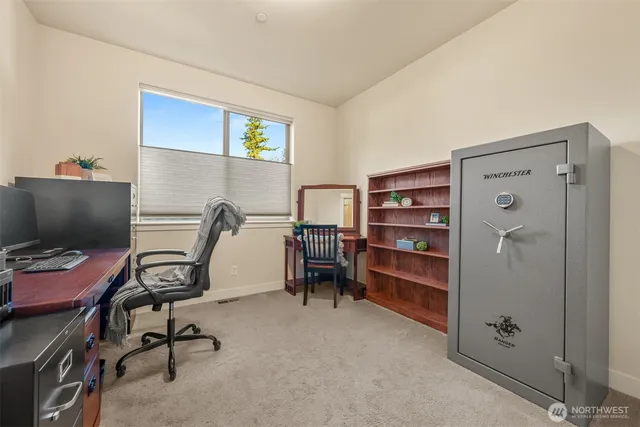 a view of a workspace with furniture and a window