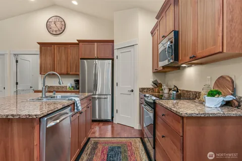 a kitchen with stainless steel appliances granite countertop a sink stove and refrigerator
