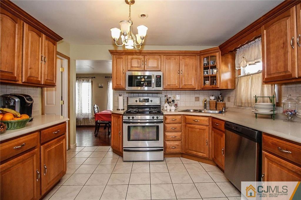 155 Princeton Road Old Bridge, NJ 08859 - Photo 3 of 18 a kitchen with stainless steel appliances granite countertop a stove top oven a sink dishwasher and cabinets with wooden floor