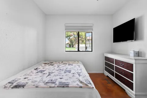 a bedroom with a bed and flat screen tv