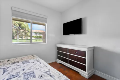 a bedroom with a bed and a large window